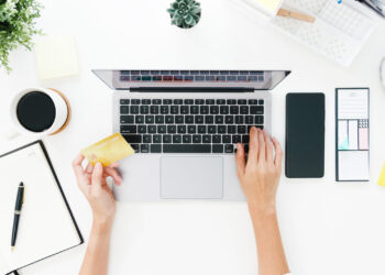 Top view of freelance Asia lady casual using laptop online shopp Top view of freelance Asia lady casual using laptop online shopping with credit card on table in living room at house. Working from home, remotely work, social distancing, quarantine for coronavirus.
